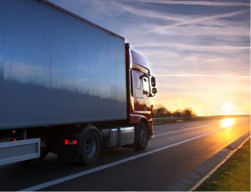 Truck driving into a sunset